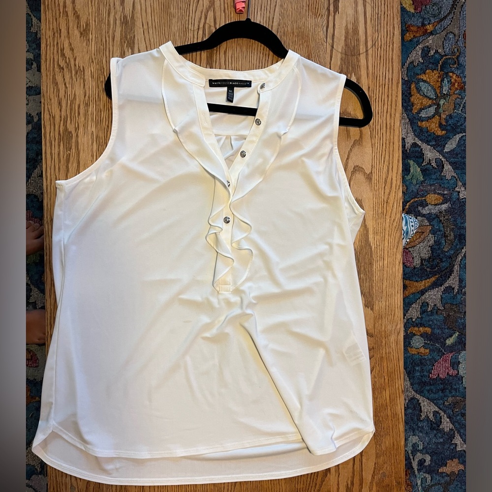 White sleeveless blouse with ruffle detail